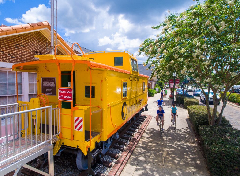 Cyclists Riding by the Train Caboose on the West Orange Trail