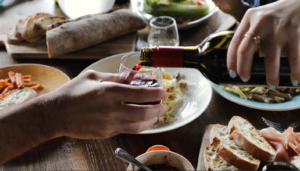 someone pouring wine into someone elses glass