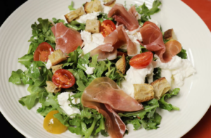 italian salad with greens, croutons, tomatoes, prosciutto, and cheese