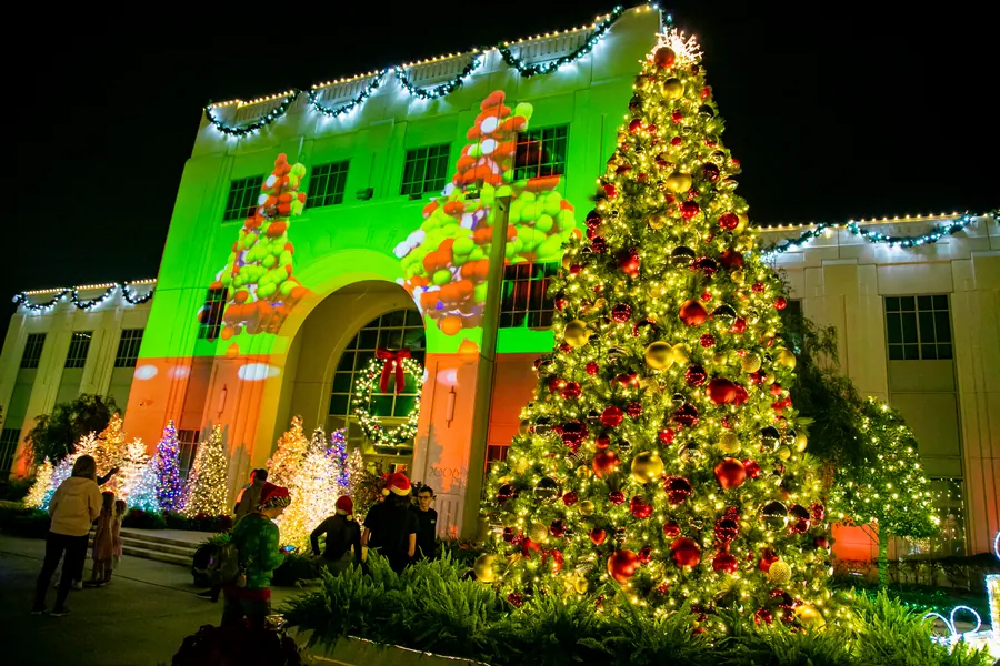 Animated light show projected on City Hall next to a Christmas tree